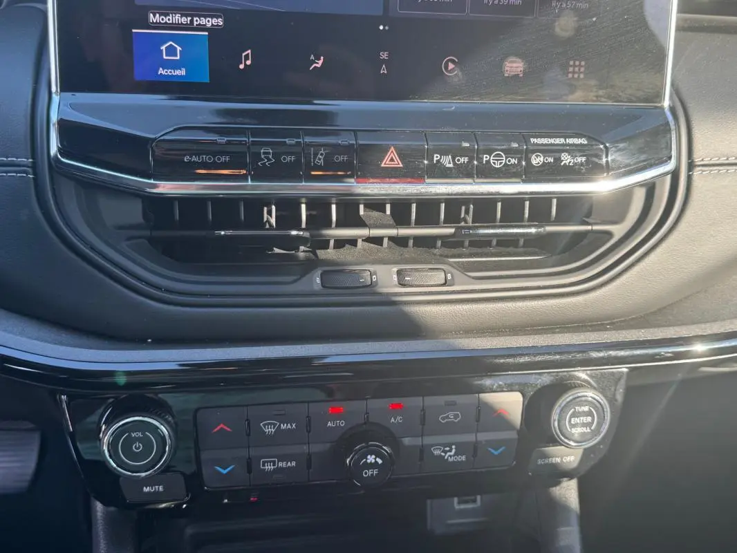 Vue rapprochée du tableau de bord du Jeep Compass 2025, montrant les commandes de climatisation et l'écran tactile.
