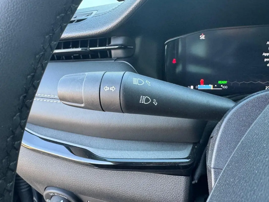 Gros plan sur la manette des clignotants et des feux dans l'habitacle du Jeep Compass bleu 2025.