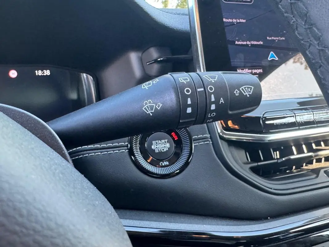 Gros plan sur la commande d’essuie-glace et le bouton start/stop du tableau de bord du Jeep Compass bleu 2025.
