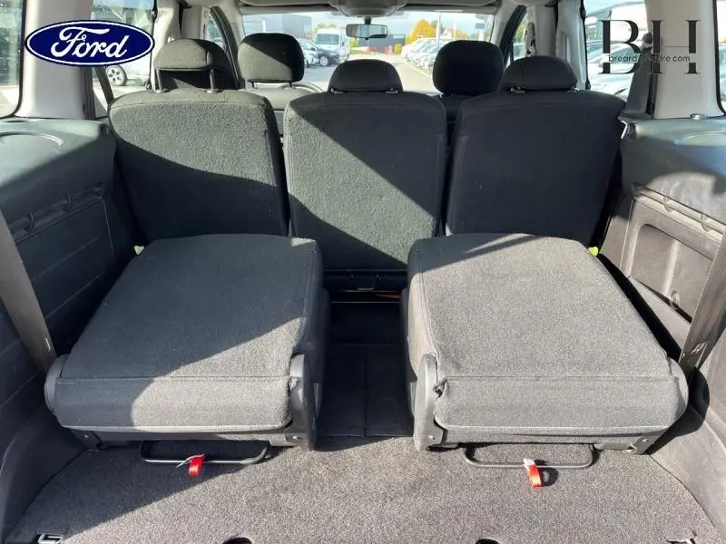 Vue arrière de l'intérieur du Citroën Berlingo blanc Banquise, sièges arrière rabattus et espace de chargement visible.