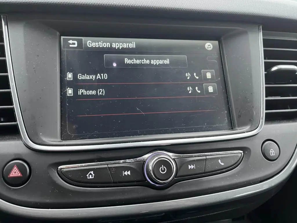 Écran tactile central de l’Opel Crossland X 2021 affichant la gestion des appareils Bluetooth, avec commandes autour en plastique noir.