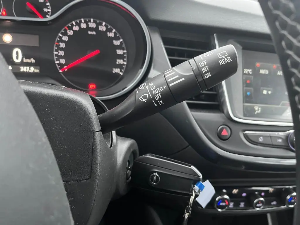 Gros plan sur la commande d'essuie-glace à droite du volant dans l'habitacle noir de l'Opel Crossland X 2021.