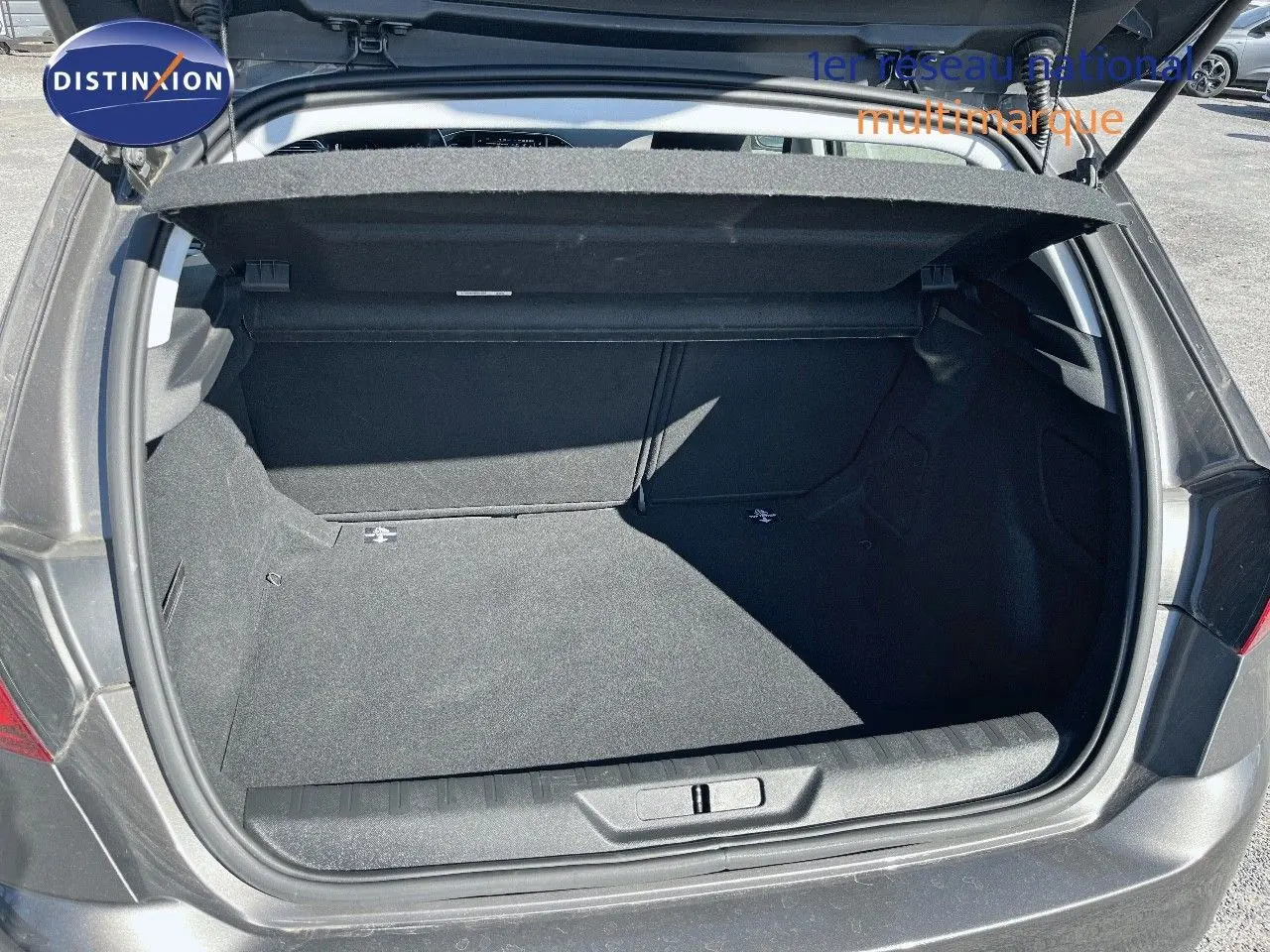 Coffre ouvert vu de l'arrière d'une Peugeot 308 Business gris foncé, montrant un espace de rangement propre et spacieux.