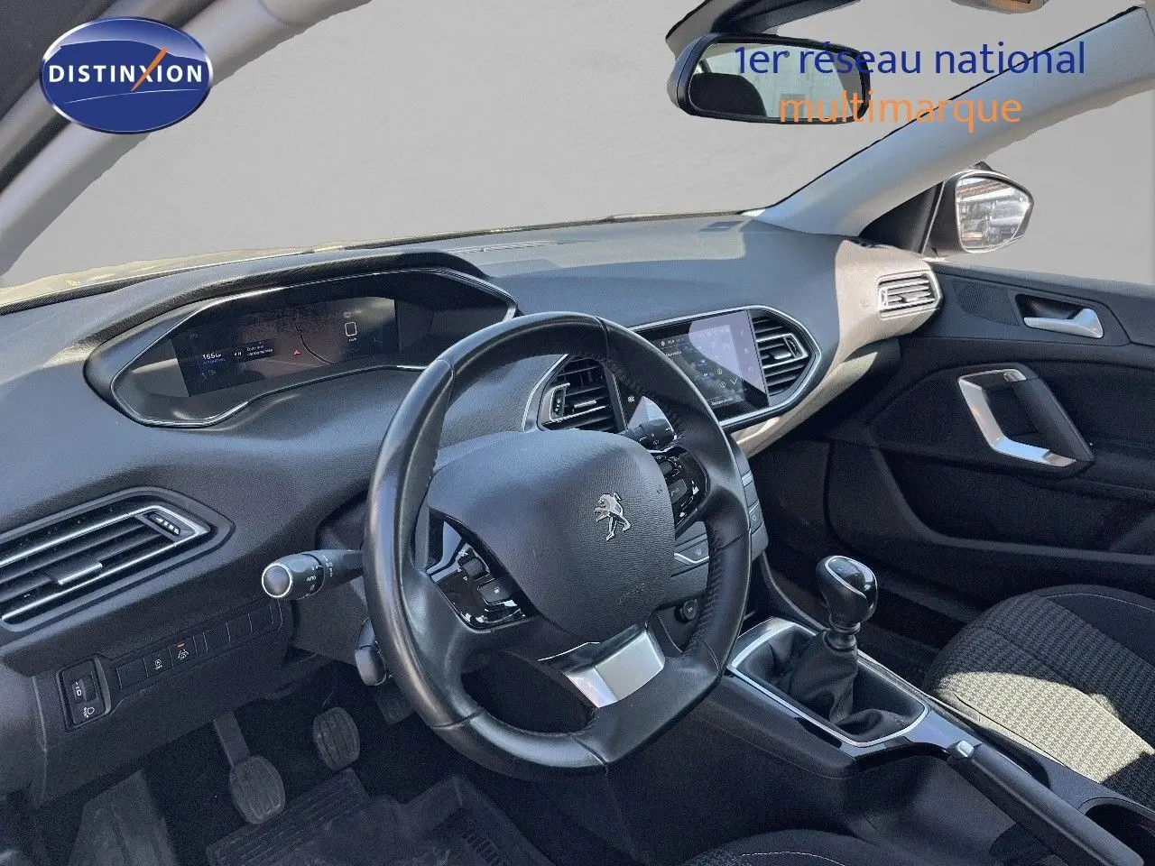 Vue intérieure du poste de conduite de la Peugeot 308 Business 2020, volant et levier de vitesses manuelle visibles.