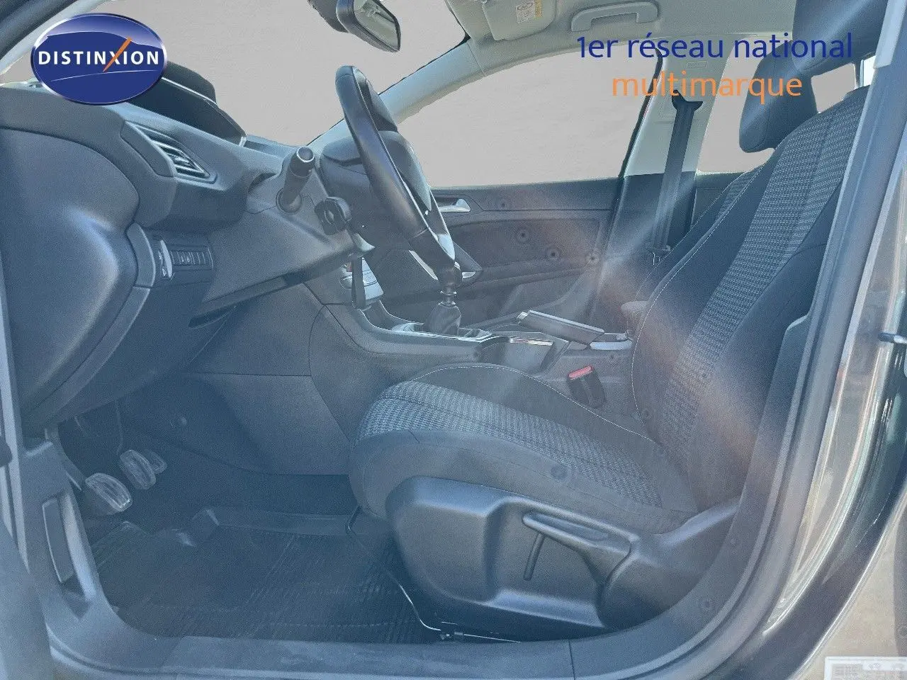 Vue intérieure côté conducteur de la Peugeot 308 Business 2020 gris foncé, montrant sièges et tableau de bord.