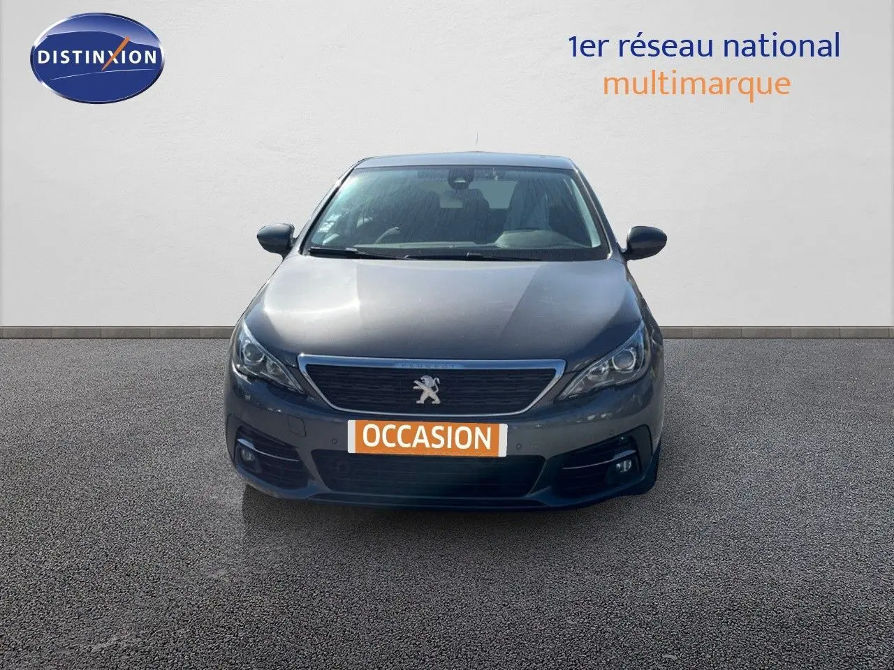 Peugeot 308 Business gris foncé vue de face, avec calandre chromée et plaque "OCCASION" visible.