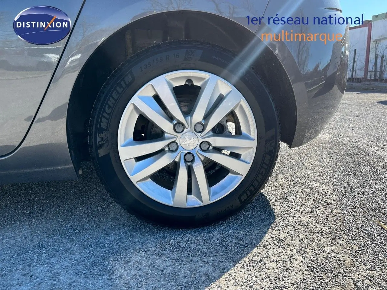 Gros plan sur la roue arrière droite d’une Peugeot 308 Business gris foncé, avec jante alliage et pneu Michelin.