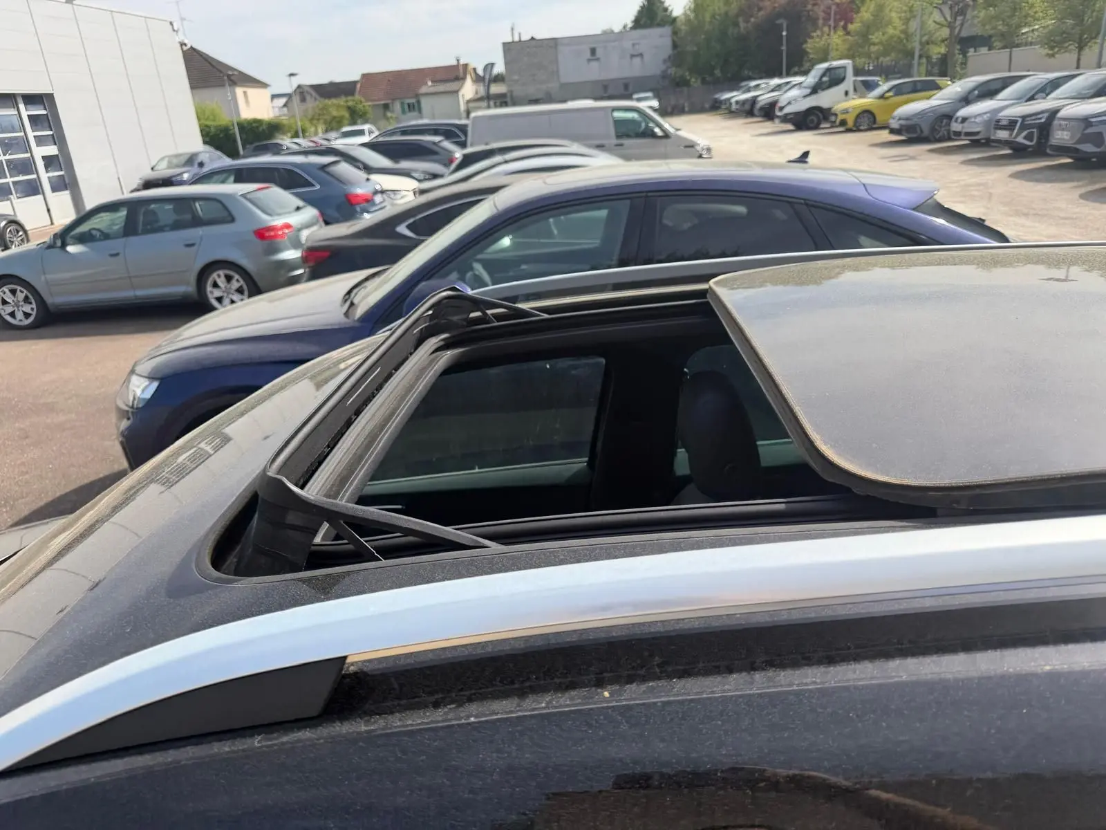 Toit ouvrant panoramique partiellement ouvert sur un SEAT Ateca noir vu de dessus côté gauche.