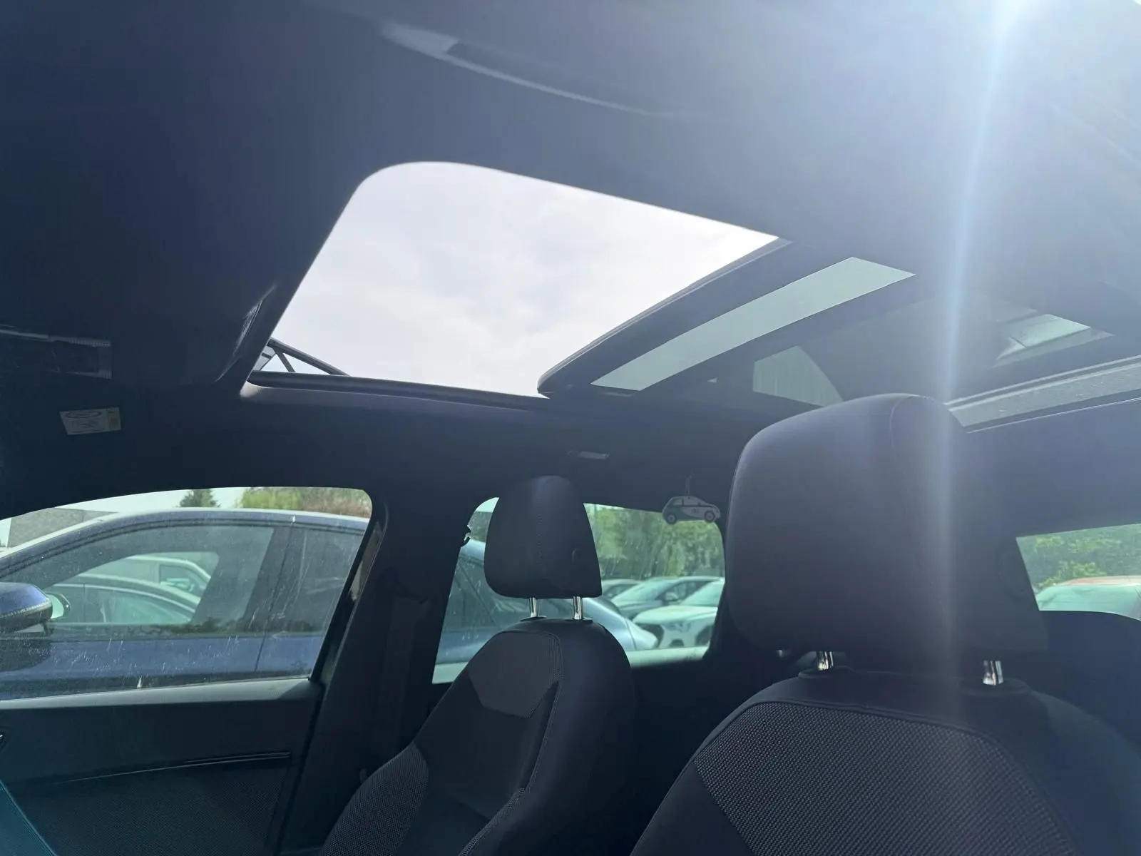 Vue intérieure du toit ouvrant panoramique et des sièges avant noirs du SEAT Ateca 2.0 TDI 116 Xcellence.