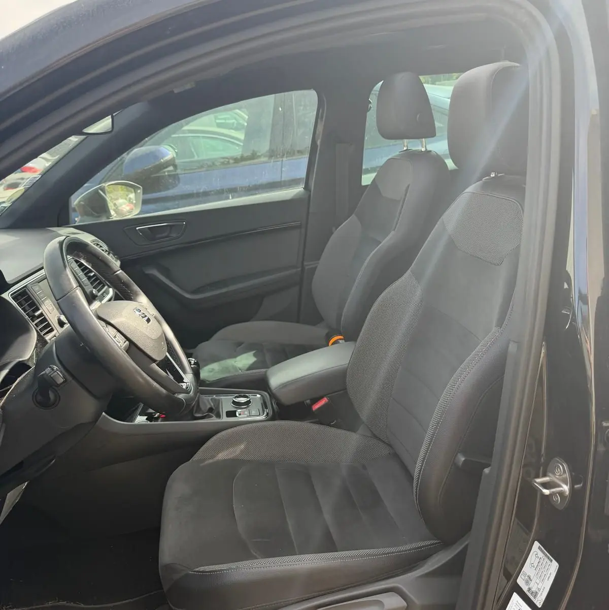 Vue intérieure côté conducteur du SEAT Ateca noir 2019, sièges en alcantara noir et volant cuir multifonctions.