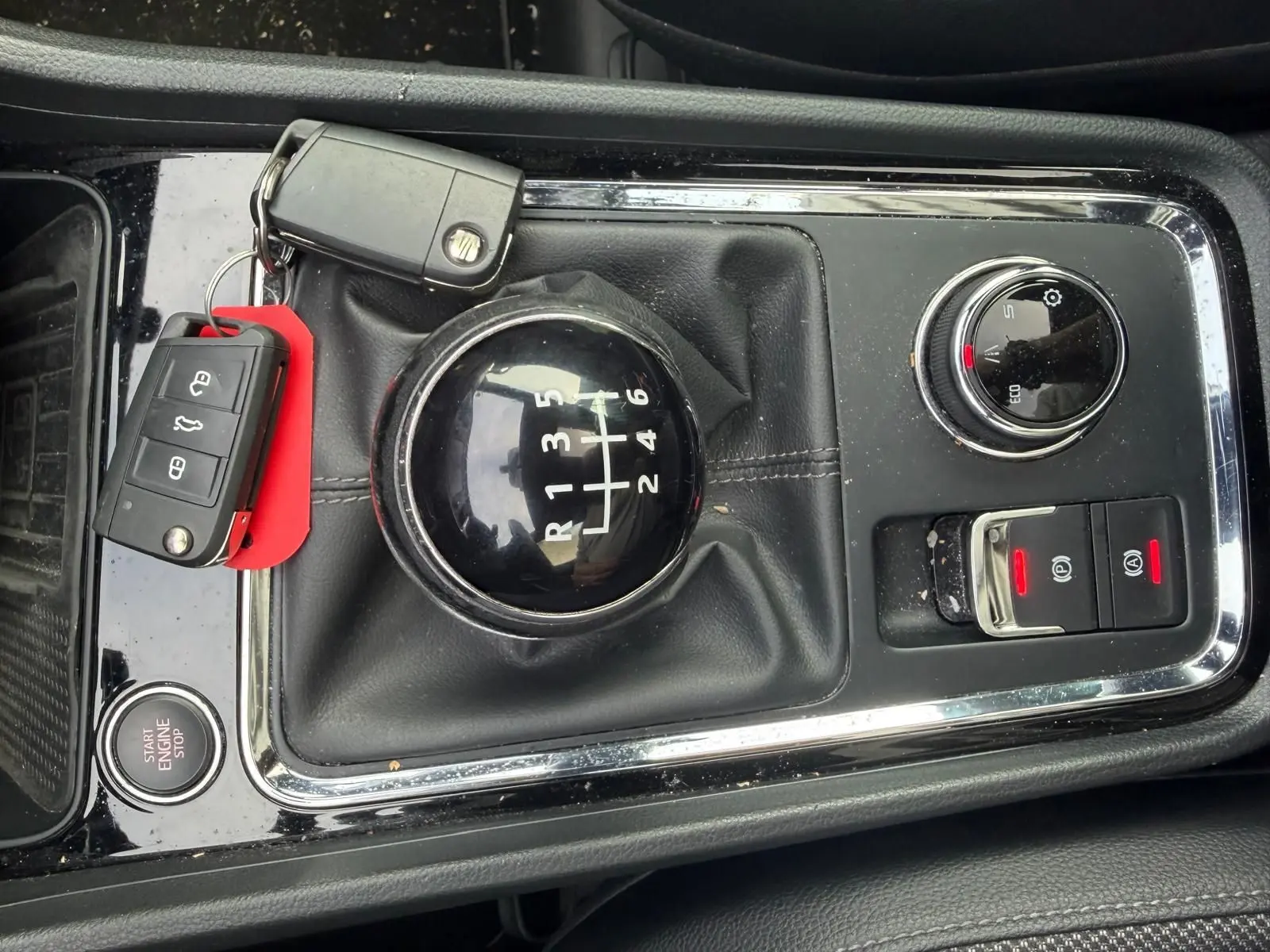 Vue rapprochée de la console centrale noire du SEAT Ateca 2.0 TDI 116 XCELLENCE avec levier de vitesse manuel et clés posées.