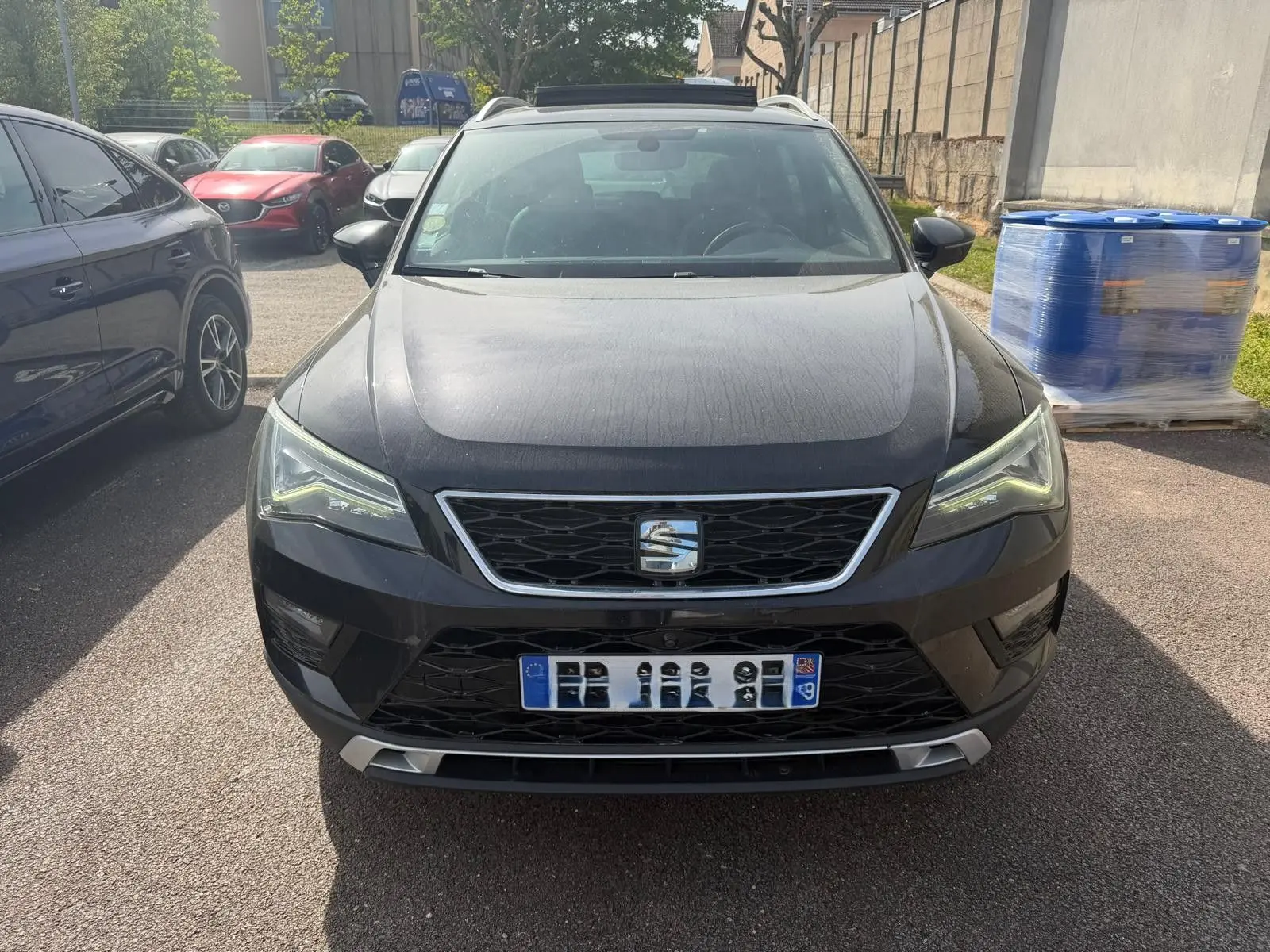 Vue avant d'un SEAT Ateca noir 2019 avec calandre chromée et phares LED allumés, stationné en extérieur.
