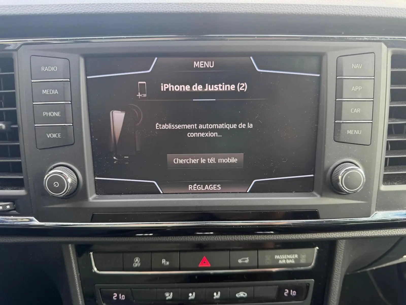Écran tactile central du tableau de bord du SEAT Ateca noir, affichant la connexion Bluetooth d’un iPhone.