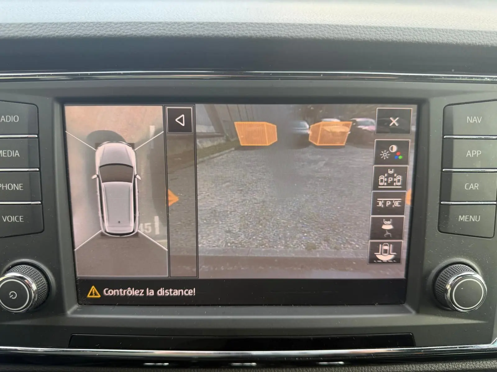 Écran de caméra de recul et vue 360° du SUV SEAT Ateca noir, affichant l'aide au stationnement active.