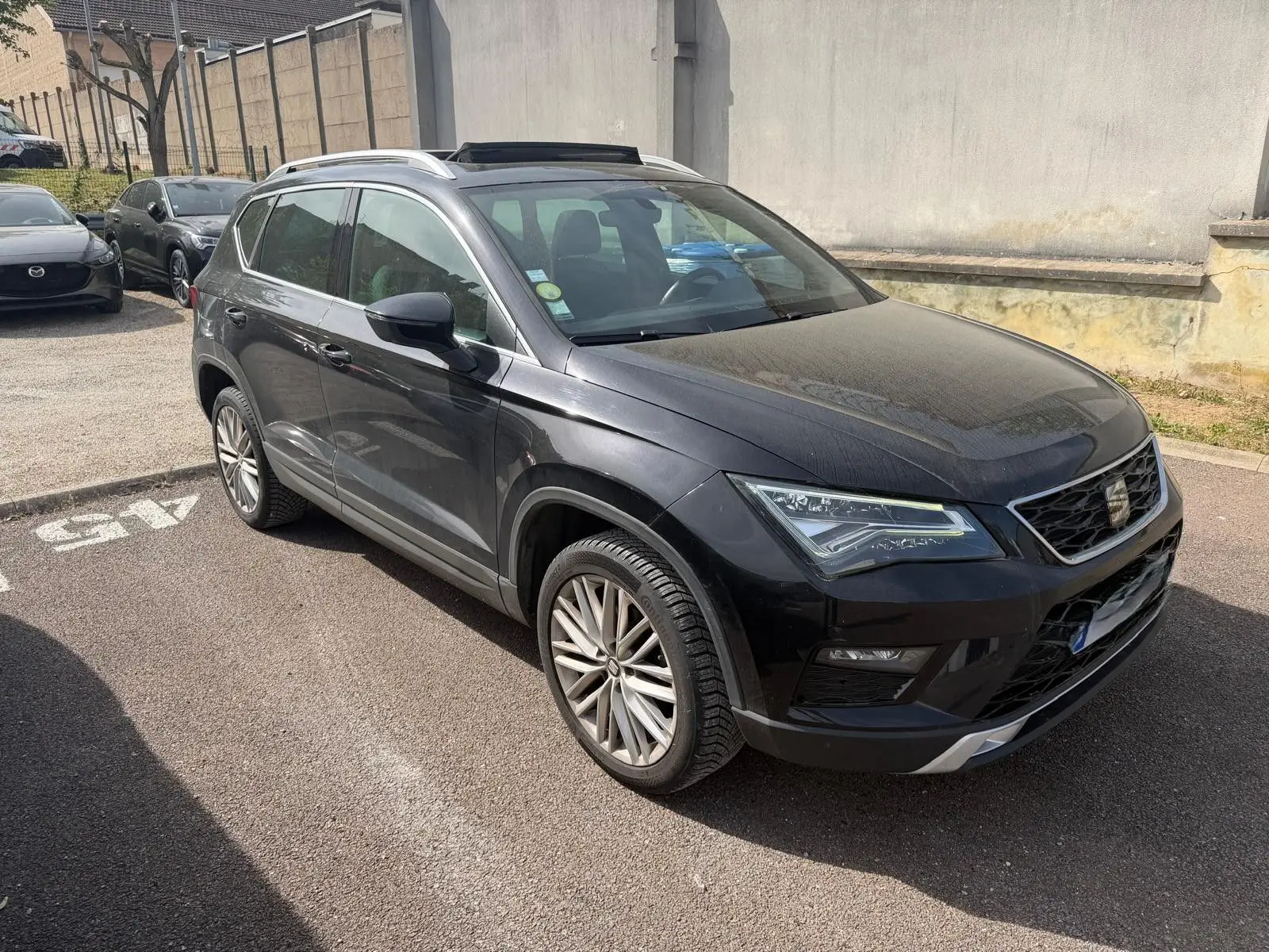 SEAT Ateca noir 2019 en 3/4 avant droit, avec jantes alliage et toit ouvrant panoramique visible.