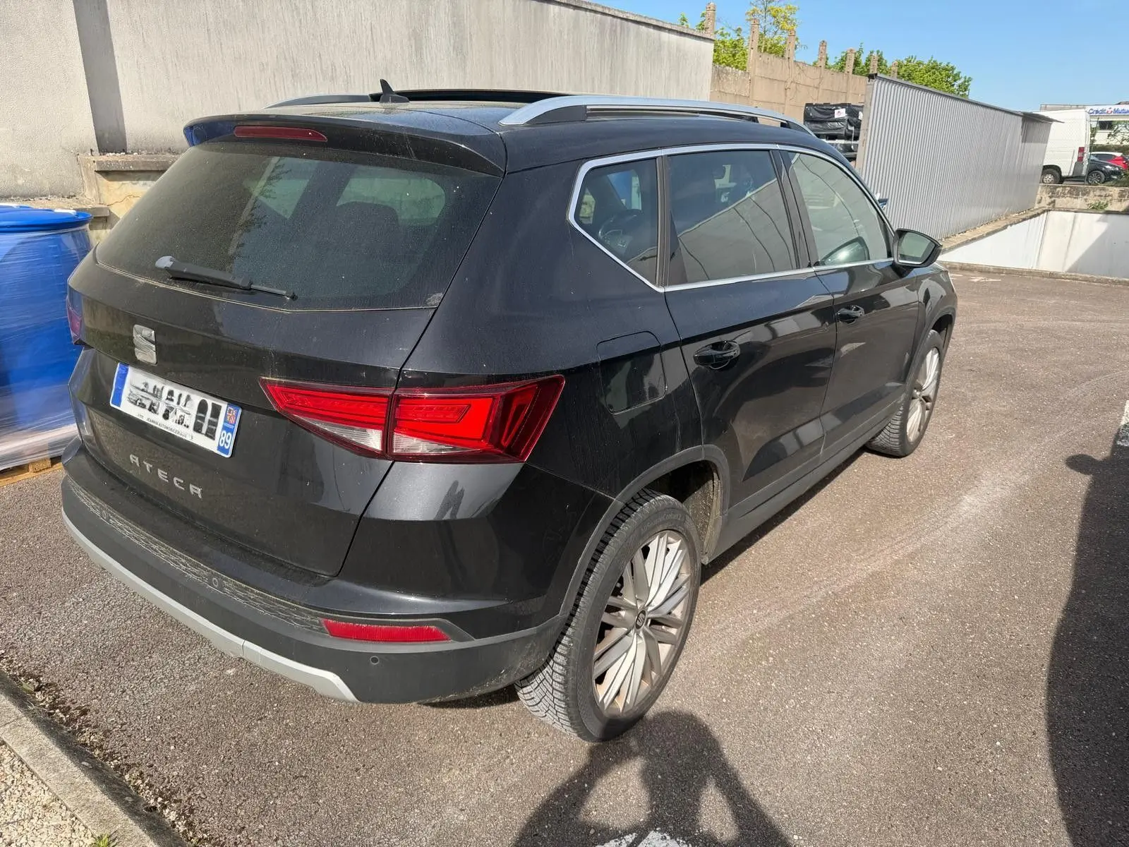 Vue 3/4 arrière droite d'un SEAT Ateca noir 2019 avec jantes alliage et feux arrière LED distinctifs.
