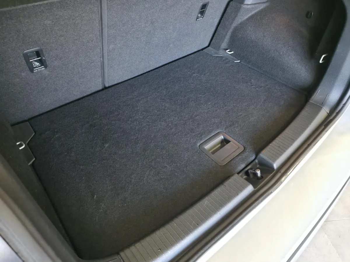 Coffre arrière ouvert du Volkswagen T-Cross gris, vue plongeante sur le plancher et les finitions intérieures.