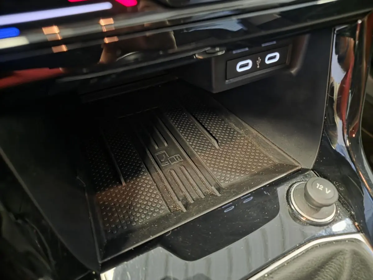 Détail de la console centrale noire avec chargeur à induction et ports USB-C du Volkswagen T-Cross gris.