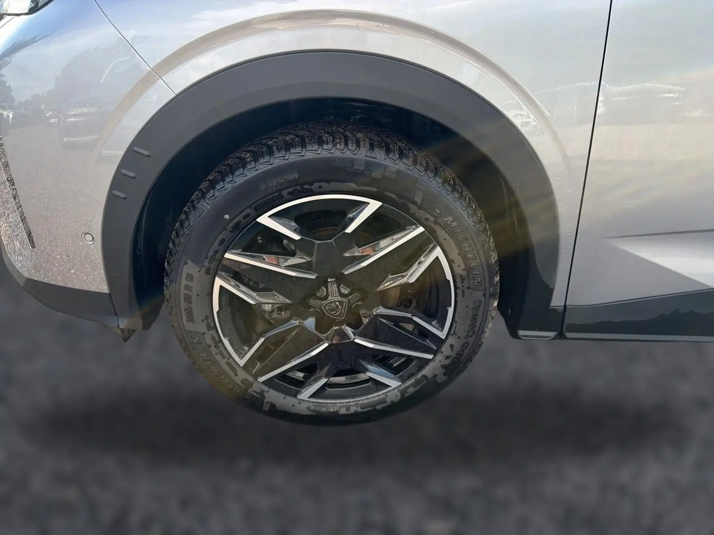 Gros plan sur la roue avant gauche du Peugeot 3008 gris Artense avec jante alu au design moderne.