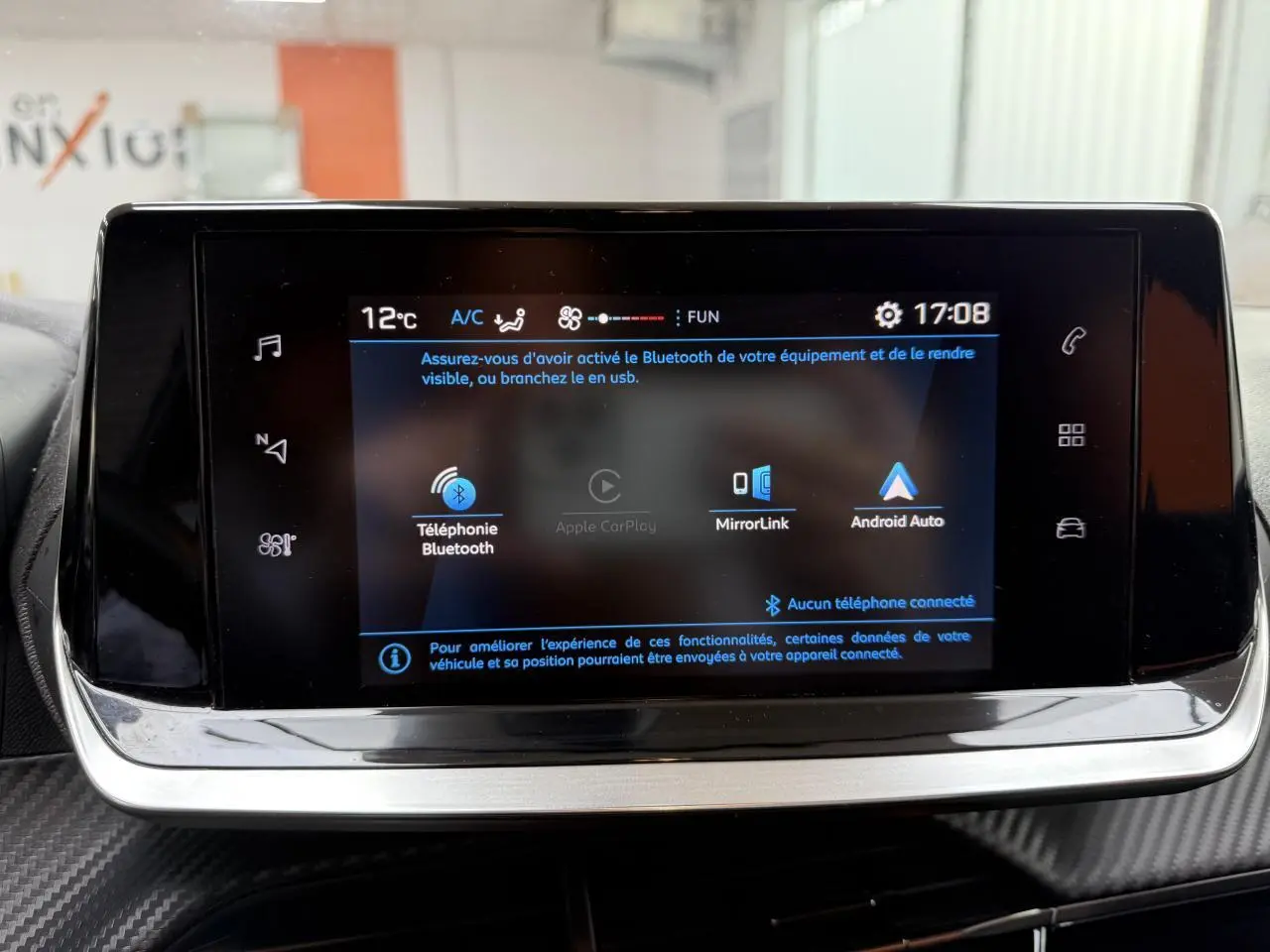 Écran tactile 7 pouces du système multimédia de la Peugeot 208 affichant les options Bluetooth, MirrorLink et Android Auto.