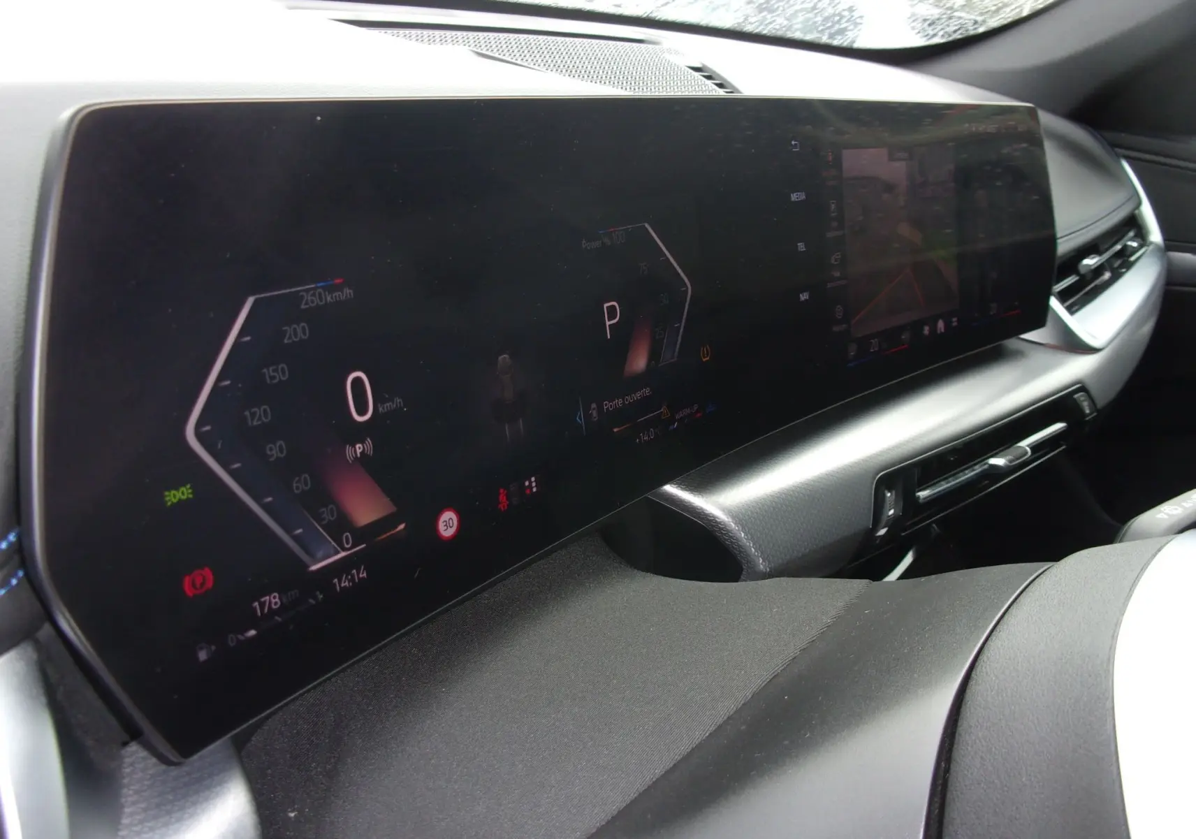 Vue rapprochée du tableau de bord numérique et écran central du BMW X1 argent métallisé, affichant la vitesse et caméra de recul.