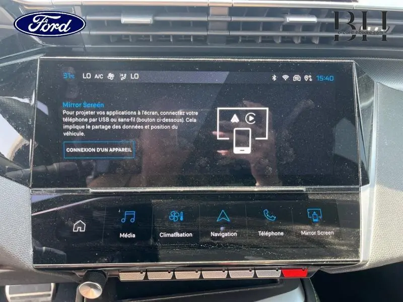 Écran tactile central d'une Ford, affichant le menu Mirror Screen avec options multimédia et navigation.