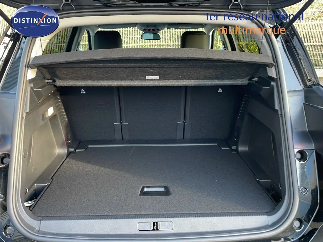 Coffre ouvert vu de l'arrière d'un Citroën C5 Aircross noir perla metal, montrant un espace de chargement spacieux et propre.