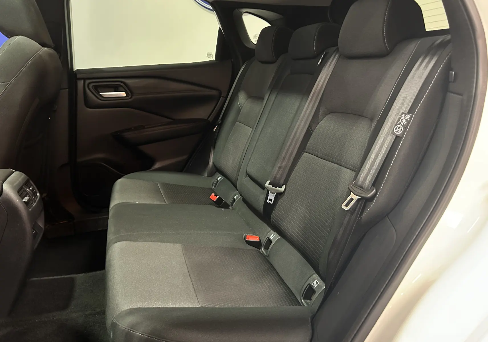 Vue intérieure côté droit des sièges arrière noirs en tissu du Nissan Qashqai blanc lunaire 2023.