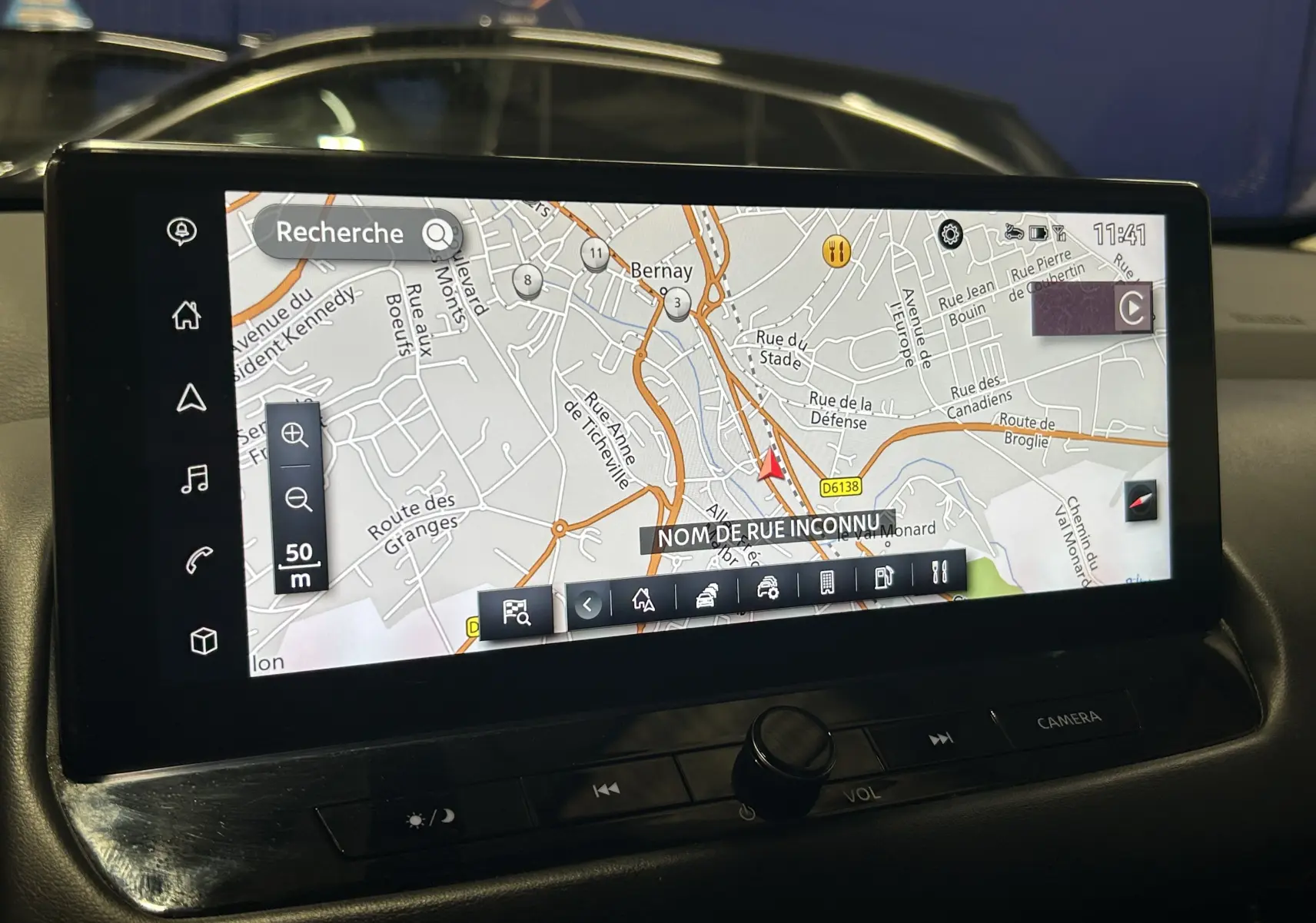 Écran tactile du GPS du Nissan Qashqai 1.3 Hybrid 2023, affichant une carte routière en intérieur véhicule.