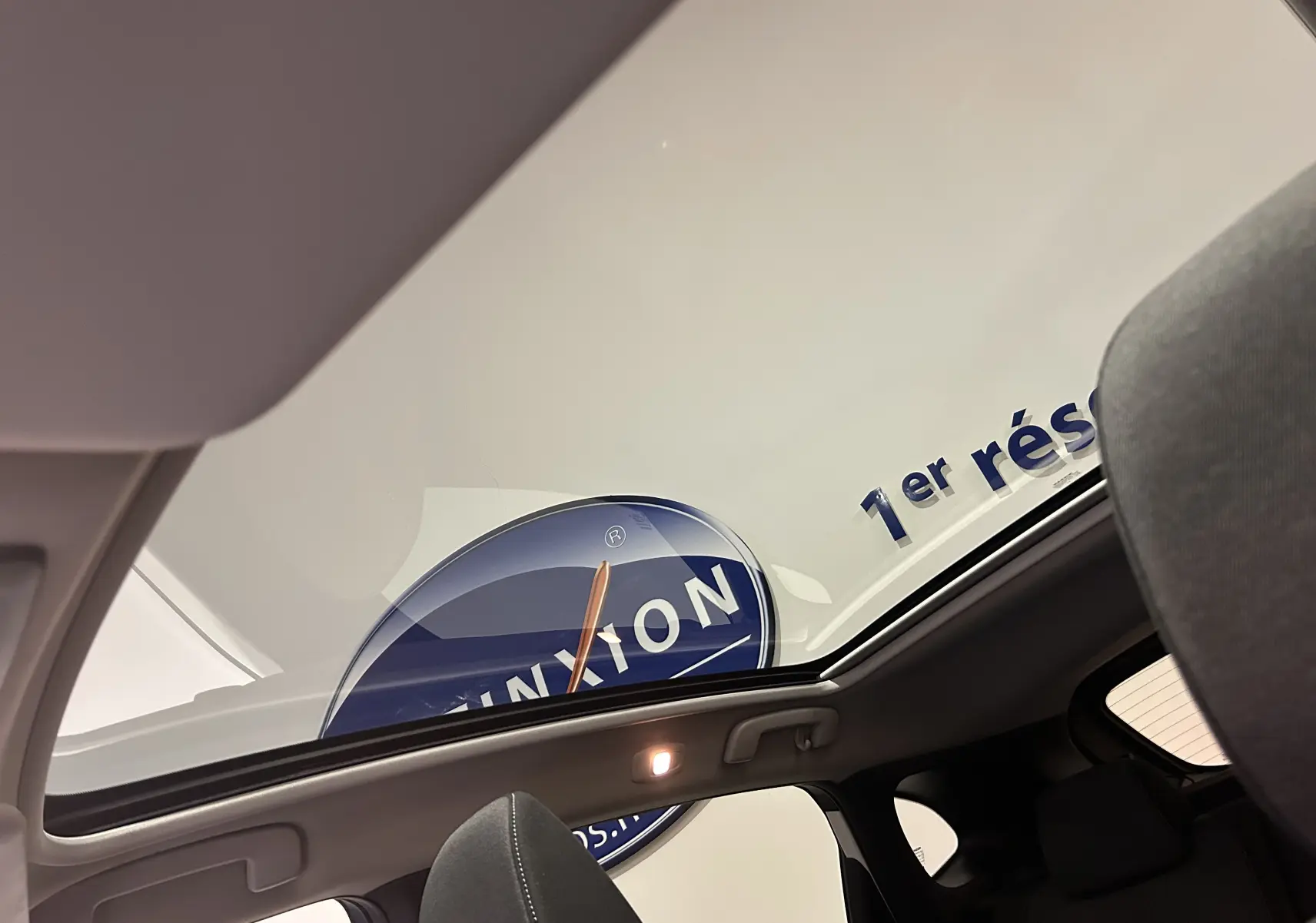 Vue intérieure du toit panoramique du Nissan Qashqai blanc lunaire, mettant en valeur la luminosité et l'espace du véhicule.