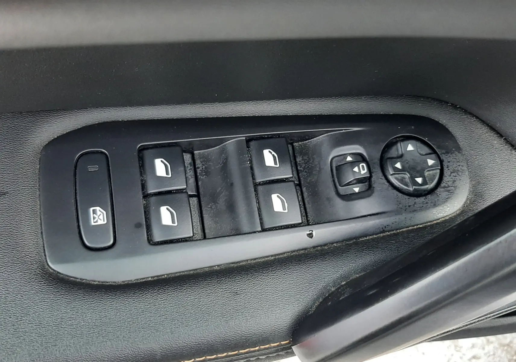 Gros plan sur les commandes de lève-vitres et réglage des rétroviseurs côté conducteur d'une Peugeot 308 SW gris Artense.