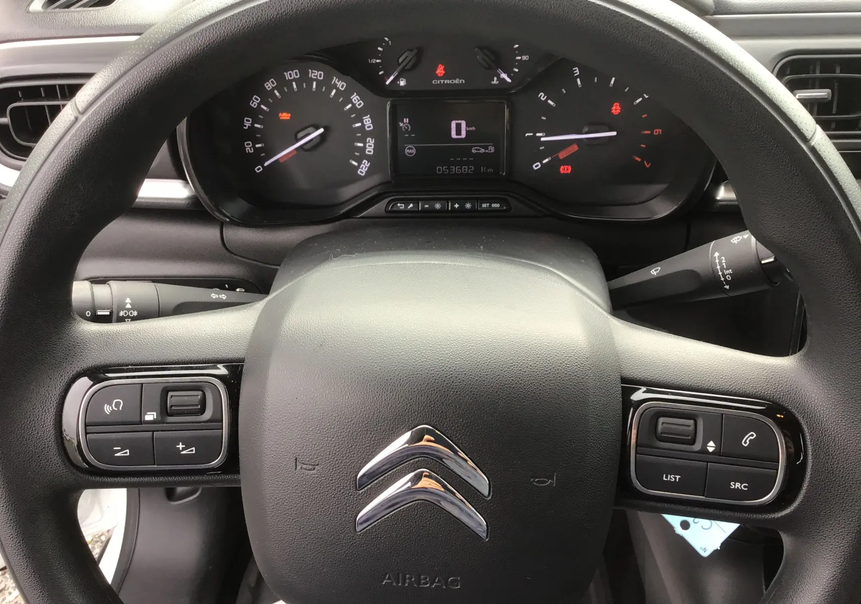 Vue intérieure centrée sur le volant noir de la Citroën C3 Société 2020, avec commandes intégrées et tableau de bord digital.