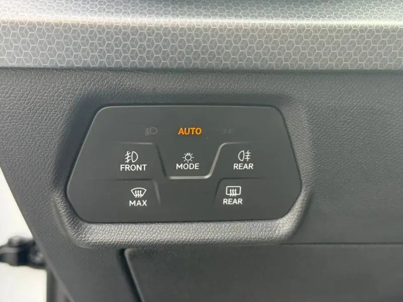 Panneau de commandes d’éclairage et dégivrage sur le côté gauche intérieur d’une SEAT Leon blanche 2025.