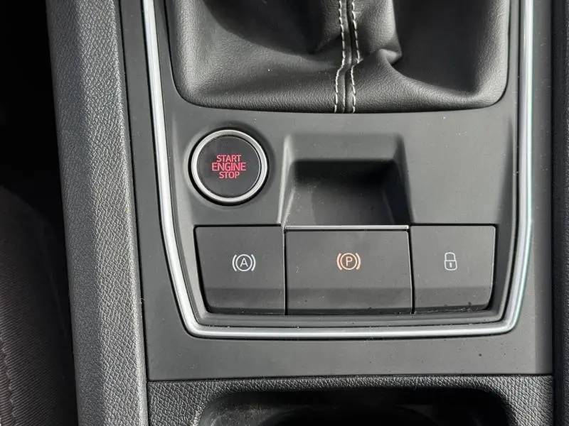 Gros plan sur la console centrale noire du SEAT LEON 2.0 TDI 115ch STYLE XL avec bouton Start/Stop et commandes électroniques.