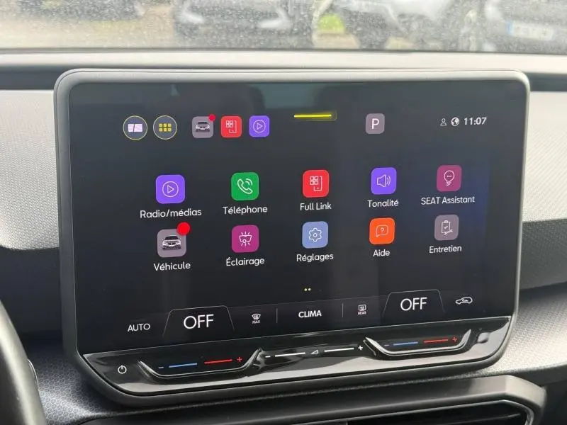 Écran tactile central du tableau de bord du SEAT Leon 2025, affichant le menu principal avec commandes climatisation en dessous.