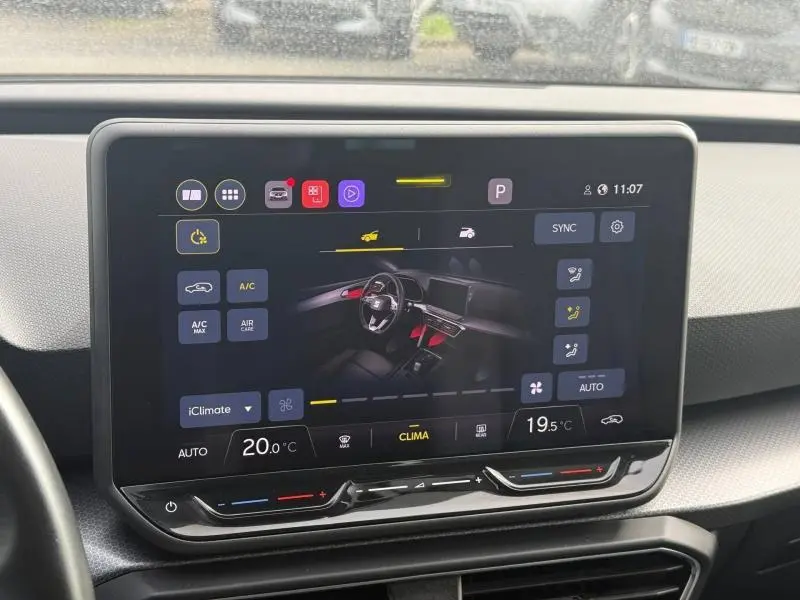 Écran tactile central affichant les commandes de climatisation du SEAT Leon blanc, vue intérieure frontale.