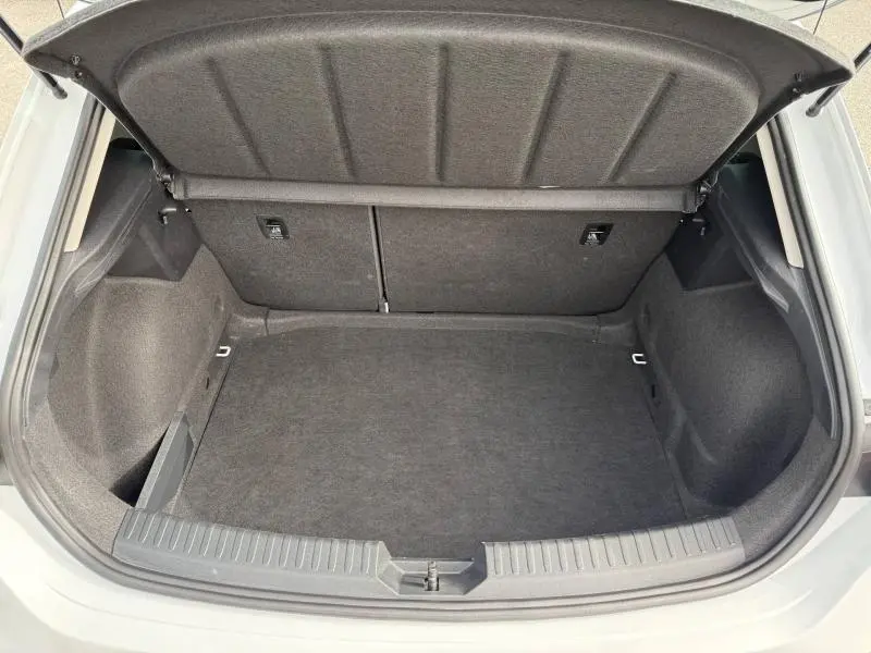 Coffre ouvert vu de l'arrière d'une SEAT LEON 2.0 TDI blanche, montrant un espace de chargement propre et spacieux.