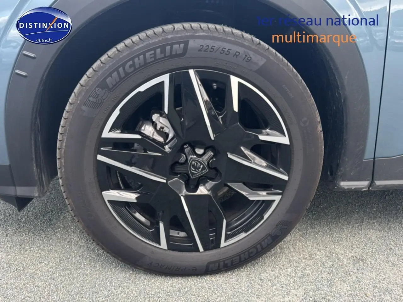 Gros plan sur la roue avant gauche du Peugeot 3008 bleu 2025 avec jante alu noire et détails argentés.