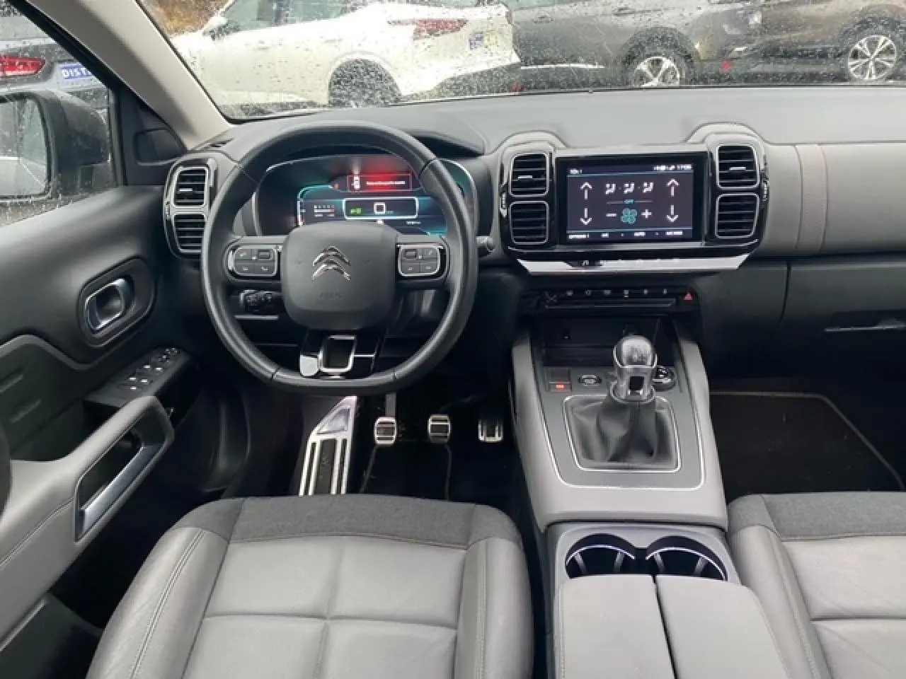 Vue intérieure avant du Citroën C5 Aircross 2019, tableau de bord gris avec écran tactile et volant multifonction.