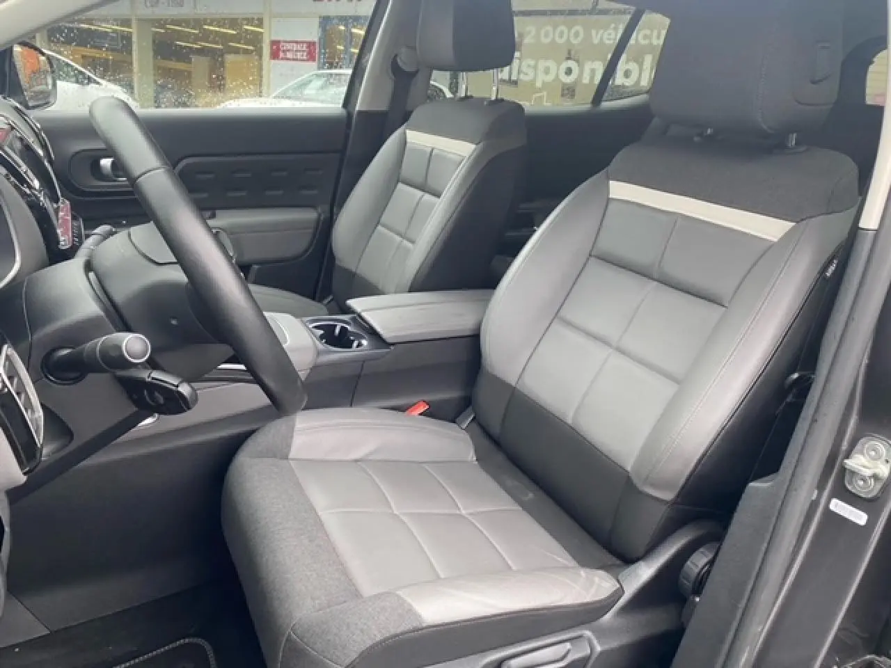 Vue intérieure côté conducteur du Citroën C5 Aircross 2019, sièges bi-matière gris et console centrale visible.