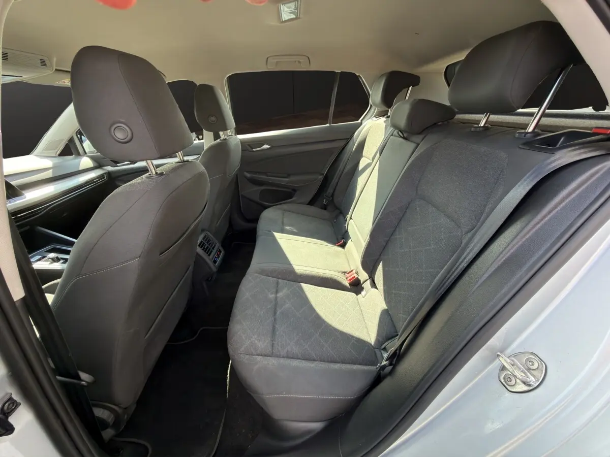 Vue intérieure côté droit des sièges arrière gris foncé de la Volkswagen Golf 2022 avec banquette 3 places et appuie-têtes.