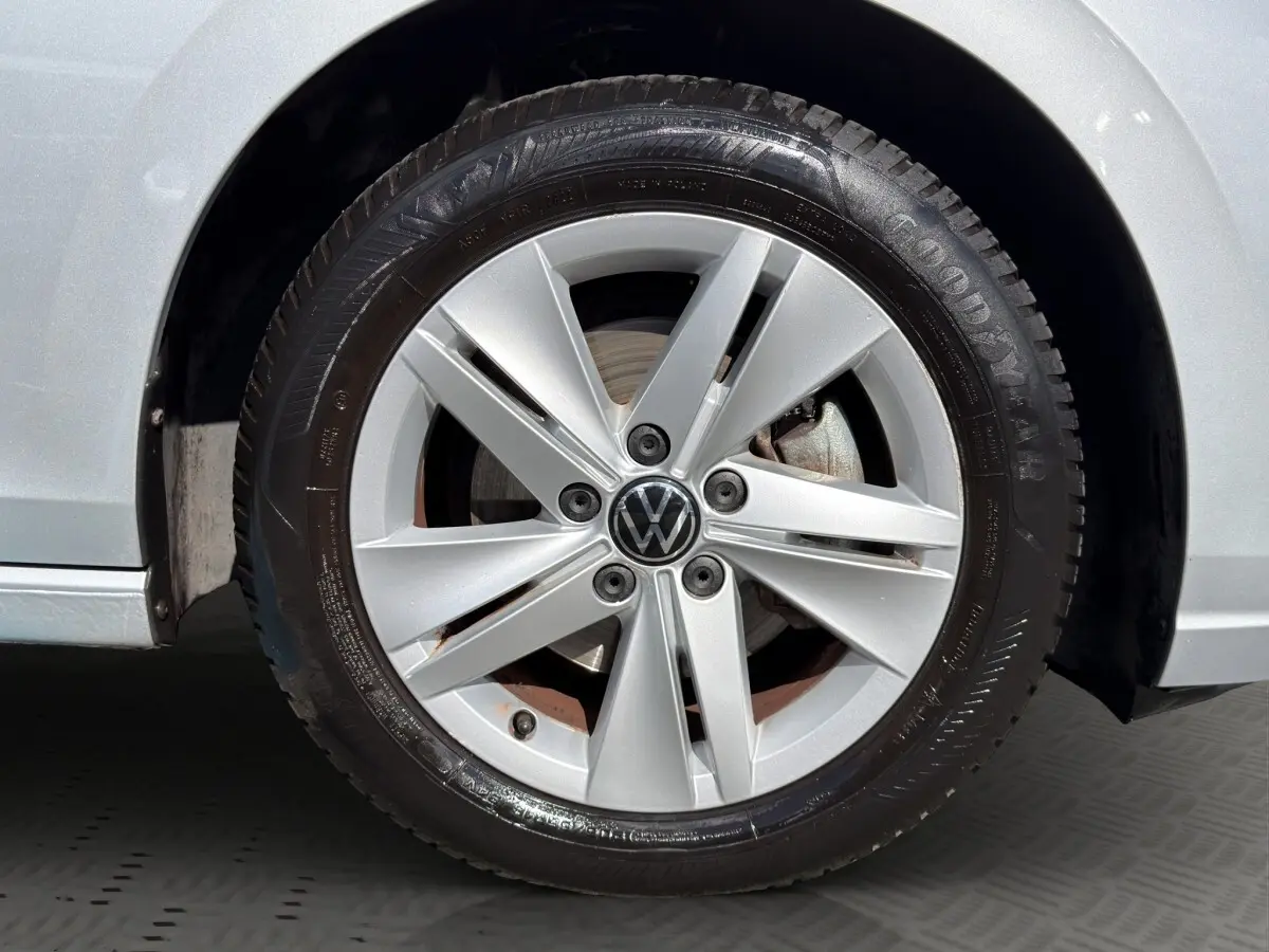Gros plan sur la roue avant droite grise d'une Volkswagen Golf 2022 avec jante alliage et logo VW central.