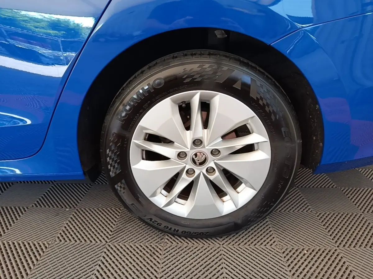 Gros plan sur la roue avant droite d’une Skoda Octavia bleue 2024 avec jante argentée et pneus Kumho.