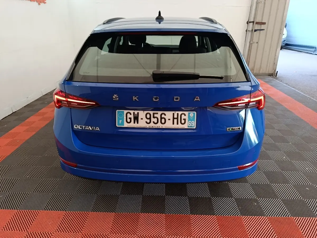 Vue arrière d'une ŠKODA Octavia bleue avec feux LED allumés et plaque d'immatriculation française visible.