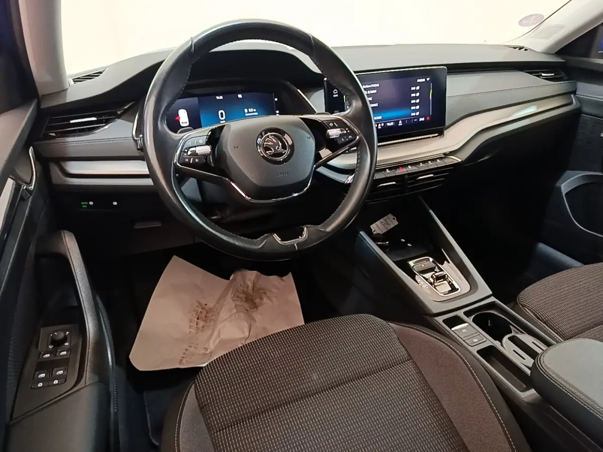 Intérieur de la Skoda Octavia 2024 vue côté conducteur, volant cuir noir et tableau de bord avec écran tactile.