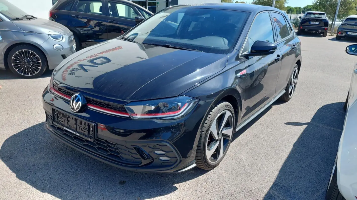 Volkswagen Polo GTI noire vue 3/4 avant droit, avec jantes alliage 17 pouces et signature lumineuse rouge distinctive.
