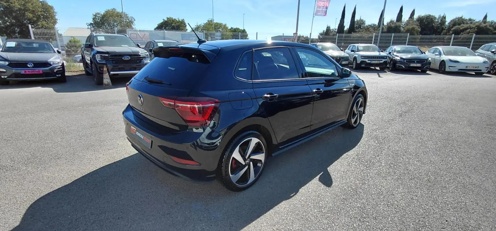 Volkswagen Polo 2.0 TSI GTI noire vue 3/4 arrière droit, avec jantes alliage 17 pouces et toit noir brillant.