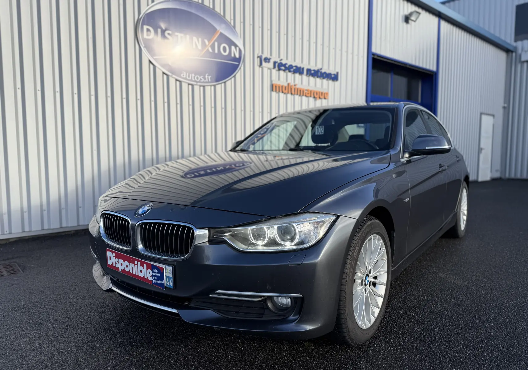 BMW Série 3 320D gris vue 3/4 avant droit avec jantes alliage et calandre caractéristique BMW.