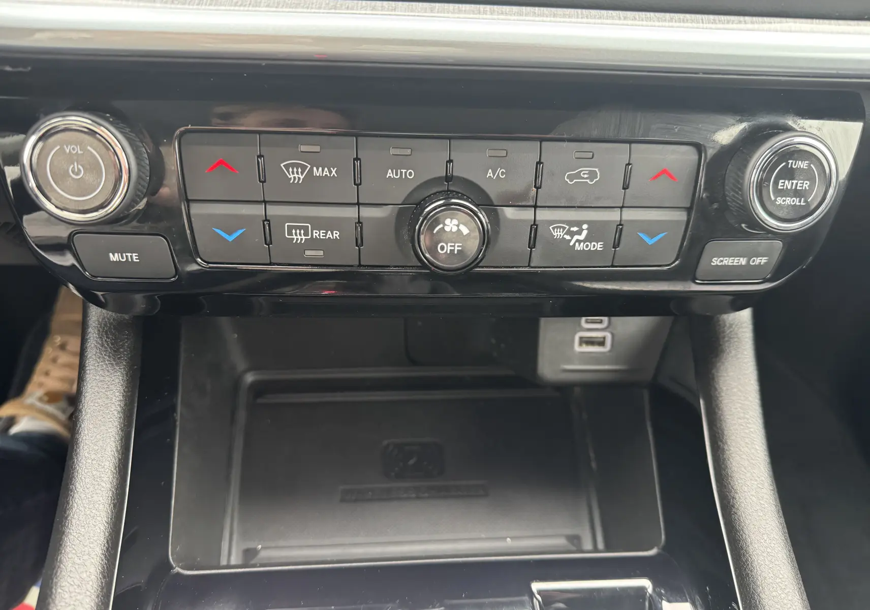 Panneau de commande de climatisation et audio du Jeep Compass 2023, avec boutons noirs et molette argentée.