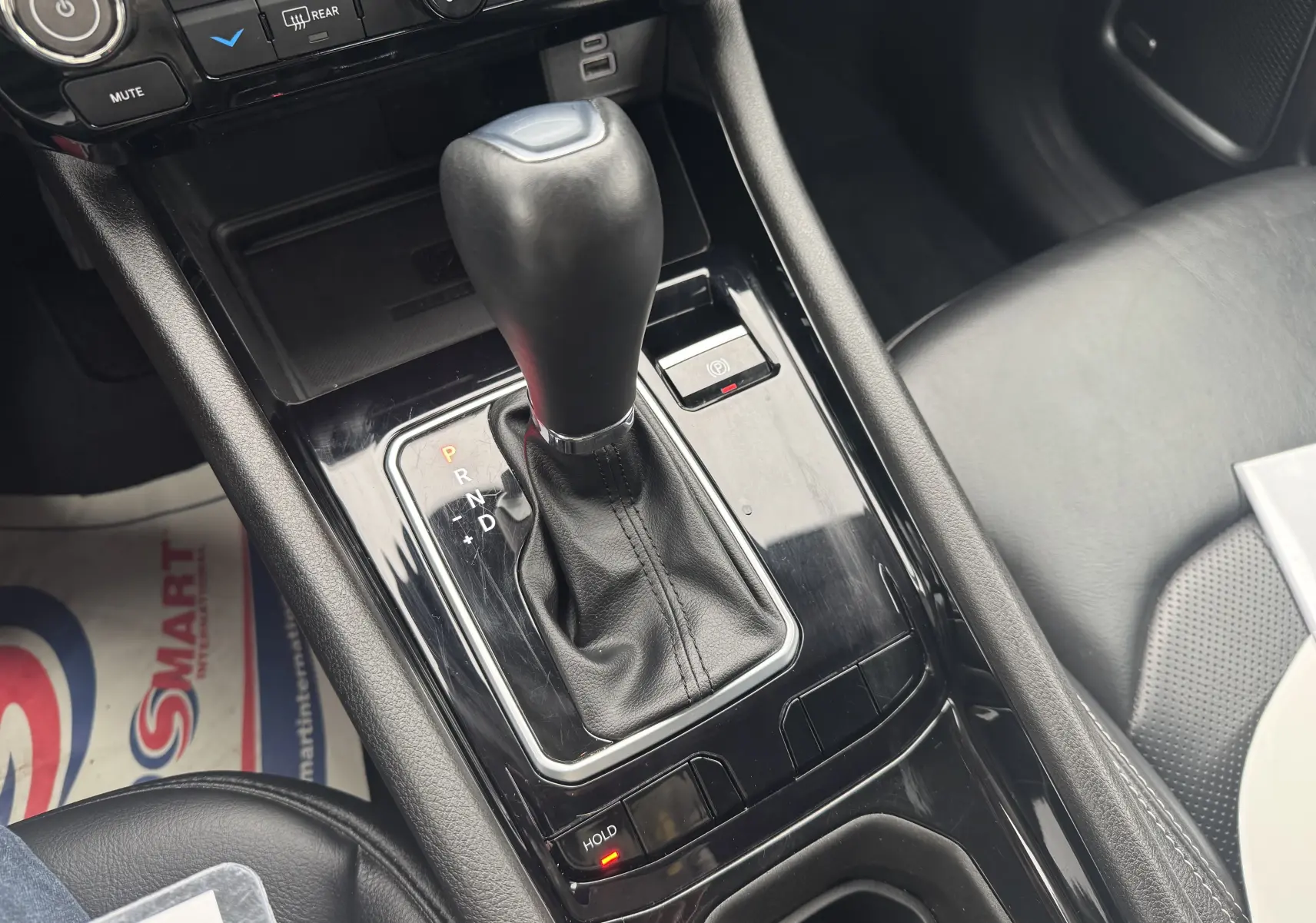 Le levier de vitesse automatique noir du Jeep Compass 2023 essence hybride, vu en gros plan dans la console centrale.